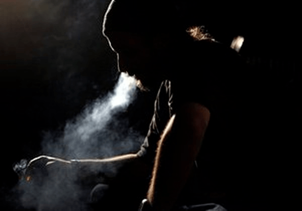 O home fuma un cigarro